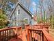 Exterior view of a home showcasing a spacious yard, elevated deck, and lush trees at 2466 Thrasher Rd, Buford, GA 30519