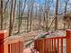 View of the backyard showing stairs with bright orange wooden railing leading to a home surrounded by a lush forest landscape at 2466 Thrasher Rd, Buford, GA 30519