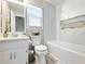 Bathroom with a white vanity, toilet, tub, glass door, and light coming from the window at 2466 Thrasher Rd, Buford, GA 30519
