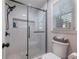 Modern bathroom with a glass-enclosed shower, tiled walls, and a window at 2466 Thrasher Rd, Buford, GA 30519