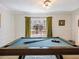 Entertaining game room features a pool table, wainscoting detail, and bright natural light from a large window at 2466 Thrasher Rd, Buford, GA 30519