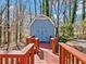 Blue outbuilding with red trim offers additional storage or workspace surrounded by a peaceful wooded backdrop at 2466 Thrasher Rd, Buford, GA 30519