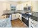 Close-up of a kitchen with white cabinets, stainless appliances, and granite countertops at 4095 Kenora Sw Dr, Atlanta, GA 30331