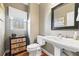 Elegant powder room featuring a pedestal sink, decorative cabinet, and a window with natural light at 1168 Blackhawk Pl, Lawrenceville, GA 30043