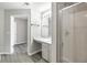 Bright bathroom with a glass door shower, gray cabinets and gray flooring at 156 Haven Oak Way, Lawrenceville, GA 30044