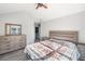 Bright bedroom features a ceiling fan, vaulted ceiling, dresser and a bed at 156 Haven Oak Way, Lawrenceville, GA 30044