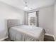 Bedroom features a ceiling fan, window and a comfortable bed and updated flooring at 156 Haven Oak Way, Lawrenceville, GA 30044