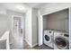 Upstairs hallway and laundry closet with white front load washer and dryer at 156 Haven Oak Way, Lawrenceville, GA 30044
