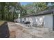 Spacious backyard featuring a stone patio, outdoor seating, a grill, and mature trees at 2418 Bolling Brook Sw Dr, Atlanta, GA 30311