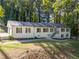 Charming single-story home with brick facade, dark shutters, and mature trees, offering a tranquil setting at 2418 Bolling Brook Sw Dr, Atlanta, GA 30311