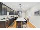 Modern kitchen featuring dark cabinets, stainless steel appliances, and a spacious island with bar seating at 2418 Bolling Brook Sw Dr, Atlanta, GA 30311