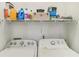 Practical laundry room with washer, dryer, and overhead storage shelf for organization at 2418 Bolling Brook Sw Dr, Atlanta, GA 30311