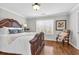 Bedroom with a large bed, stylish decor, hardwood floors and natural light from the window at 420 Heritage Park Nw Trce # 22, Kennesaw, GA 30144