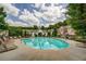 Community pool area featuring lounge chairs, lush trees and well maintained building exterior at 420 Heritage Park Nw Trce # 22, Kennesaw, GA 30144