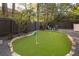 Lush backyard featuring a putting green and Adirondack chairs surrounding a fire pit at 1308 Fairview Ne Rd, Atlanta, GA 30306