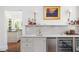 Modern bar features a sink, wine cooler, marble backsplash, and view of kitchen at 1308 Fairview Ne Rd, Atlanta, GA 30306