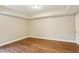 This bedroom offers ample space, a neutral color palette, and wood floors at 645 Trailmore Pl, Roswell, GA 30076