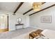 Main bedroom featuring exposed wood beams, elegant chandelier, and a view into the en suite bathroom at 645 Trailmore Pl, Roswell, GA 30076