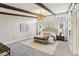 Main bedroom with exposed beams, a plush bed, and a cozy reading bench, bathed in natural light at 645 Trailmore Pl, Roswell, GA 30076