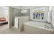 Luxurious bathroom featuring a soaking tub, separate glass shower, and decorative stained glass window at 1345 Bridgemill Ave, Canton, GA 30114