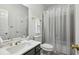 Well-lit bathroom featuring a marble countertop, sleek fixtures, and a shower with a sheer curtain at 1345 Bridgemill Ave, Canton, GA 30114