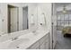 Bathroom with double sinks, a large mirror, white cabinetry, and a view into an adjacent bedroom at 1345 Bridgemill Ave, Canton, GA 30114