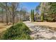 Charming traditional home with a long driveway lined with lush greenery and mature trees at 1345 Bridgemill Ave, Canton, GA 30114