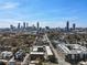Aerial view features townhomes and buildings surrounded by mature trees with a city skyline at 345 Glen Iris Ne Dr # 5, Atlanta, GA 30312
