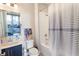 Cozy bathroom with blue vanity, subway tile, shower-tub combo, stylish fixtures, and a view of the living room at 345 Glen Iris Ne Dr # 5, Atlanta, GA 30312