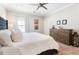 Bright bedroom featuring a tufted headboard, ceiling fan, and dresser with decorative accents at 345 Glen Iris Ne Dr # 5, Atlanta, GA 30312