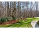 Lush backyard with green grass, various plants, mulched areas, mature trees, and patio seating at 3816 Turnberry Ct, Duluth, GA 30096