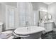 Bright bathroom with a luxurious soaking tub and shuttered arched window offering ample natural light at 3816 Turnberry Ct, Duluth, GA 30096