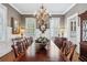 Formal dining room with long table, chandelier, and wainscoting at 3816 Turnberry Ct, Duluth, GA 30096