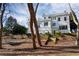 Charming white home with a rooftop deck, three car garage, and stairs leading to a well manicured lawn at 3816 Turnberry Ct, Duluth, GA 30096