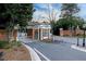 Picturesque community gatehouse featuring brick accents, manicured landscaping, and street lighting at 3816 Turnberry Ct, Duluth, GA 30096