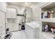 Clean laundry room with white cabinets, countertops, and front load washer and dryer at 3816 Turnberry Ct, Duluth, GA 30096