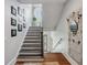 Elegant staircase with black and white steps, metal railings, and decorative wall art at 3816 Turnberry Ct, Duluth, GA 30096