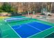 Bright blue and green tennis and pickleball courts, next to benches and a playground at 3816 Turnberry Ct, Duluth, GA 30096