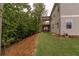 The backyard features green grass, some trees, as well as a back deck and patio at 427 Parkbrook Way, Canton, GA 30114