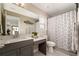 Neutral bathroom featuring gray vanity, granite counters, vanity seating, decorative mirror, and patterned shower curtain at 427 Parkbrook Way, Canton, GA 30114
