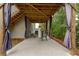 View of the patio area featuring wooden support beams, concrete flooring, and privacy curtains at 427 Parkbrook Way, Canton, GA 30114