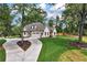 Stunning aerial view of a beautifully landscaped home with a circular driveway and lush greenery at 6110 Harvest Way, Cumming, GA 30028