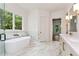 Bright bathroom featuring a soaking tub, glass shower, and double vanity with great natural light at 6110 Harvest Way, Cumming, GA 30028