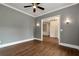 Bedroom with hardwood floors, neutral walls, ceiling fan, and access to other rooms at 6110 Harvest Way, Cumming, GA 30028