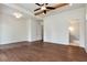 Spacious bedroom with hardwood floors, ceiling fan, walk-in closet, and view into a bathroom at 6110 Harvest Way, Cumming, GA 30028