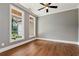 Bedroom with hardwood floors, two windows, ceiling fan, and neutral-colored walls at 6110 Harvest Way, Cumming, GA 30028