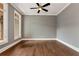Bedroom with hardwood floors, two windows, ceiling fan, and neutral-colored walls at 6110 Harvest Way, Cumming, GA 30028