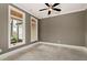 A cozy den offers natural light with its large windows and features a modern ceiling fan at 6110 Harvest Way, Cumming, GA 30028