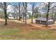 Home exterior framed by mature trees in a large lot, alongside a matching storage shed at 6110 Harvest Way, Cumming, GA 30028