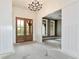 A home's foyer features a decorative light fixture, elegant wooden doors, and is freshly painted and clean at 6110 Harvest Way, Cumming, GA 30028